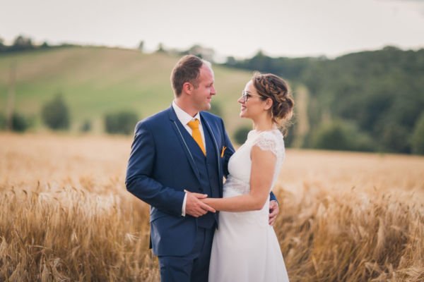 Mariés devant un champs de blé Douce lumière pour ce moment de complicité des mariés
