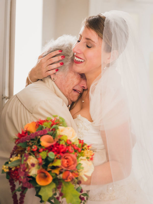 La grand mère de la mariée pleure d'émotion, la mariée la tient dans ses bras