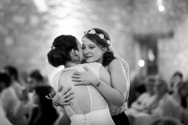 Mariée et sa témoin se prenant dans les bras et pleurant d'émotion