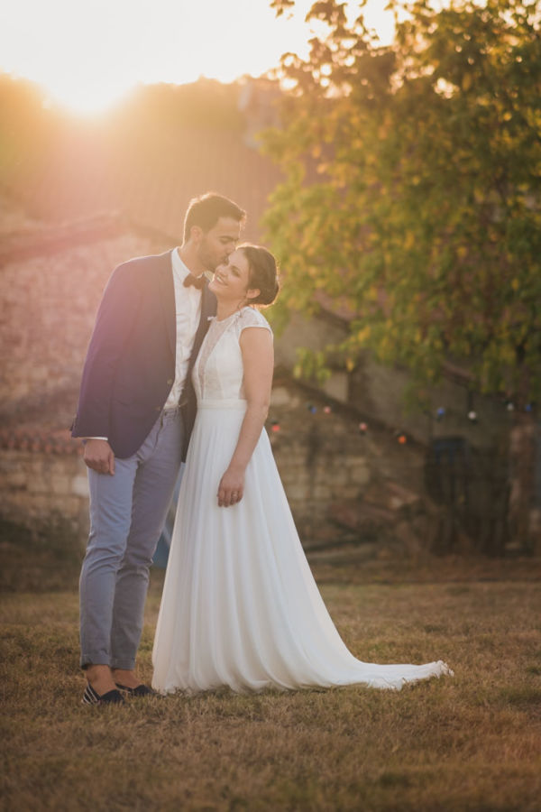 Couple de mariés enlacés au coucher du soleil