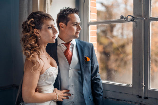 Couple de mariés regardant à la fenêtre