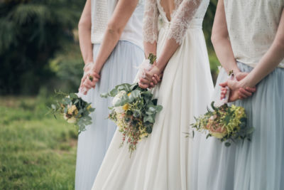 mariées et ses demoiselles d'honneur de dos tenant chacune leurs bouquets respectifs