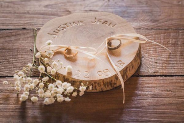 Alliances des mariés sur un socle en bois brut