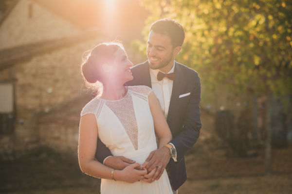 Couple de mariés enlacés au coucher du soleil