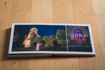 photo d'un album de mariage avec les mariés de nuit devant un château