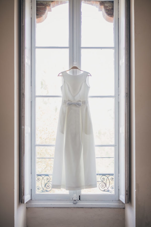 Robe de la mariée suspendue devant une fenêtre