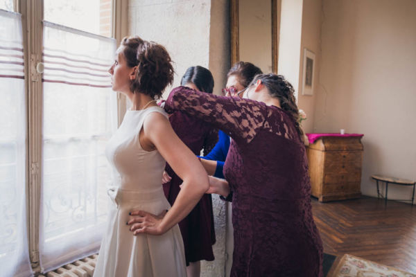 Témoins de la mariée qui l'aident à fermer sa robe
