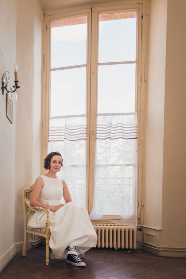 Mariée assise devant une fenêtre