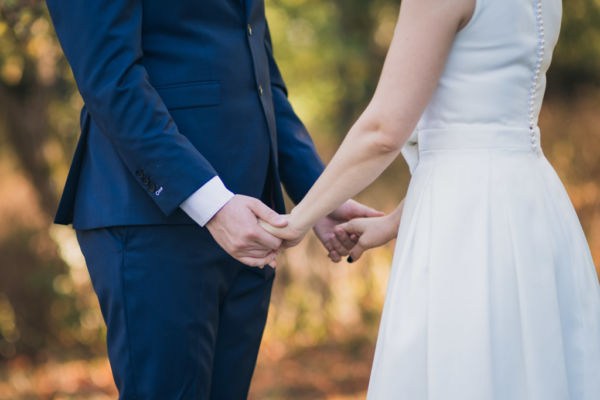 Couple de mariés se tenant face à face par les mains