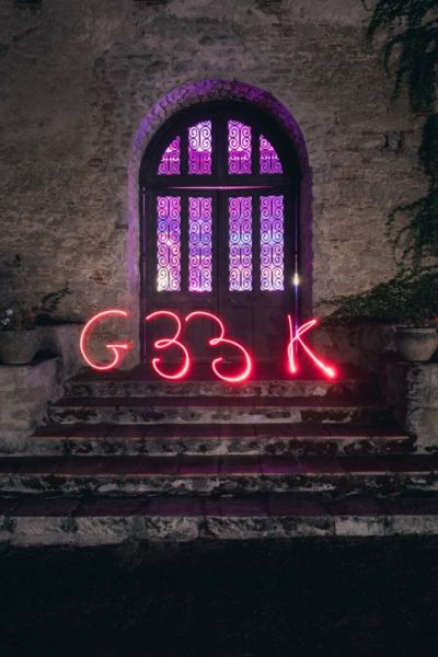 Ecriture du mot GEEK en lightpainting de nuit devant la porte fermée de la salle de récéption