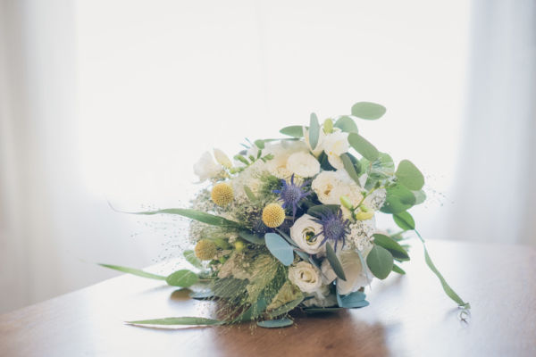 Le bouquet de la mariée composé de fleurs blanches et de feuilles d'eucalyptus