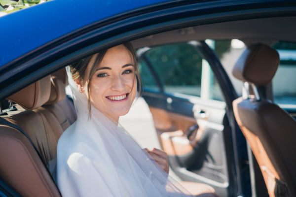 Portrait de la mariée radieuse assise dans la voiture