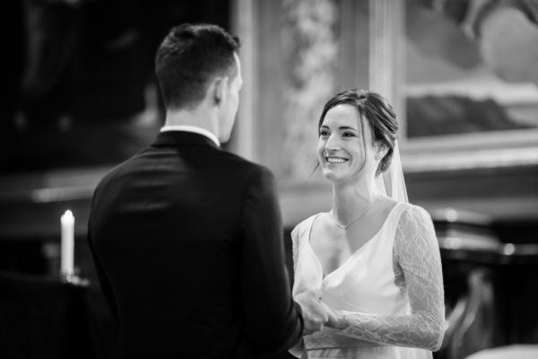 La mariée regarde en souriant son futur époux dans l'église.