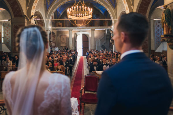 Vue par dessus les épaules des deux mariés sur tous les invités rassemblés dans l'église.