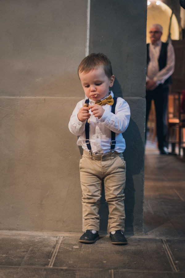 Un petit garçon mange dans l'église pendant la cérémonie de mariage