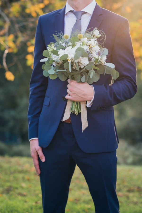 Gros plan sur le bouquet de la mariée tenue par le marié