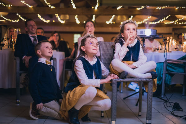 Enfants qui regardent la vidéo préparée par les amis des mariés lors de la soirée du mariage